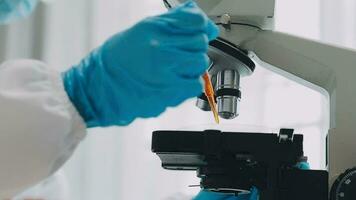 hand of scientist with test tube and flask in medical chemistry lab blue banner background video