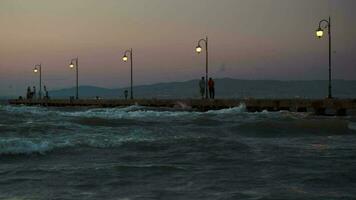 People on pier in the windy evening video