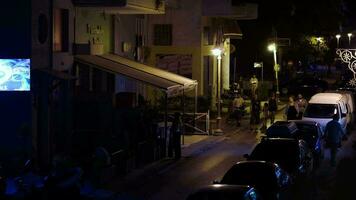 People walking along narrow street in Greece at night video