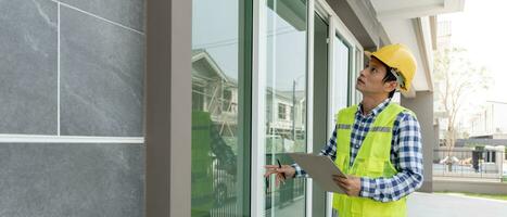 inspector or engineer is inspecting construction and quality assurance new house using a checklist. Engineers or architects or contactor work to build the house before handing it over to the homeowner photo