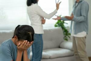 problema en familia. hija utilizar manos cubrir tu cara y sensación estresado desde el padres disputa. niño es tener mental problema. peleas, violencia, depresión, suicidio, desánimo, social problema foto