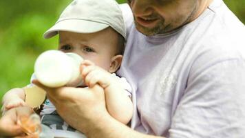 Young father feeding his baby from the bottle video