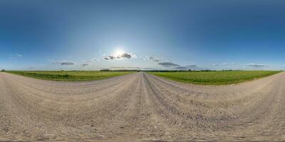 360 hdri panorama on gravel road with clouds and sun on blue sky in equirectangular spherical  seamless projection, use as sky replacement in drone panoramas, game development sky dome or VR content photo