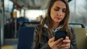 público transporte. mujer en tranvía utilizando teléfono inteligente, lento movimiento video