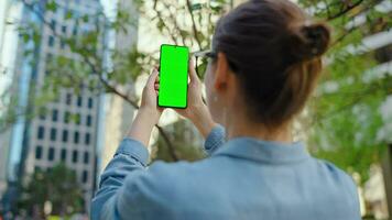 femme fait du une photo par téléphone intelligent avec vert écran video