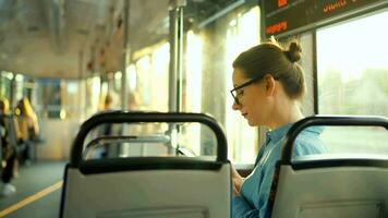 Publique transport. femme dans tram en utilisant téléphone intelligent, retour voir. video