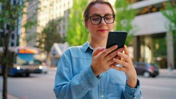 caucasiano mulher dentro óculos carrinhos dentro a meio do a cidade e usando Smartphone video