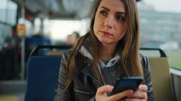 Public transport. Woman in tram using smartphone, slow motion video