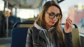 Öffentlichkeit Transport. Frau im Brille im Straßenbahn mit Smartphone video