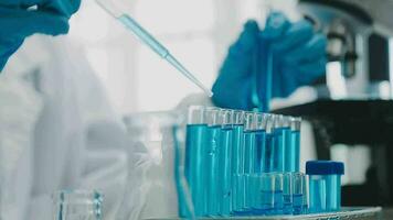mano de científico con prueba tubo y matraz en médico química laboratorio azul bandera antecedentes video