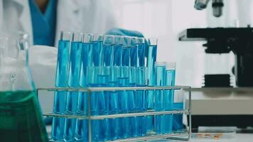 hand of scientist with test tube and flask in medical chemistry lab blue banner background video