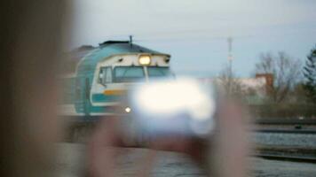 Woman with phone shooting arriving train video