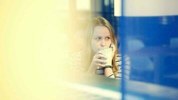 Woman in the cafe having a phone talk while drinking tea video