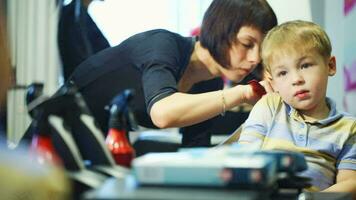 Little child getting his hair cut at the hairdressing saloon video