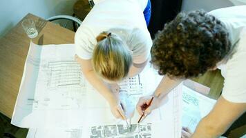 Male and female architects during work with construction schemes video