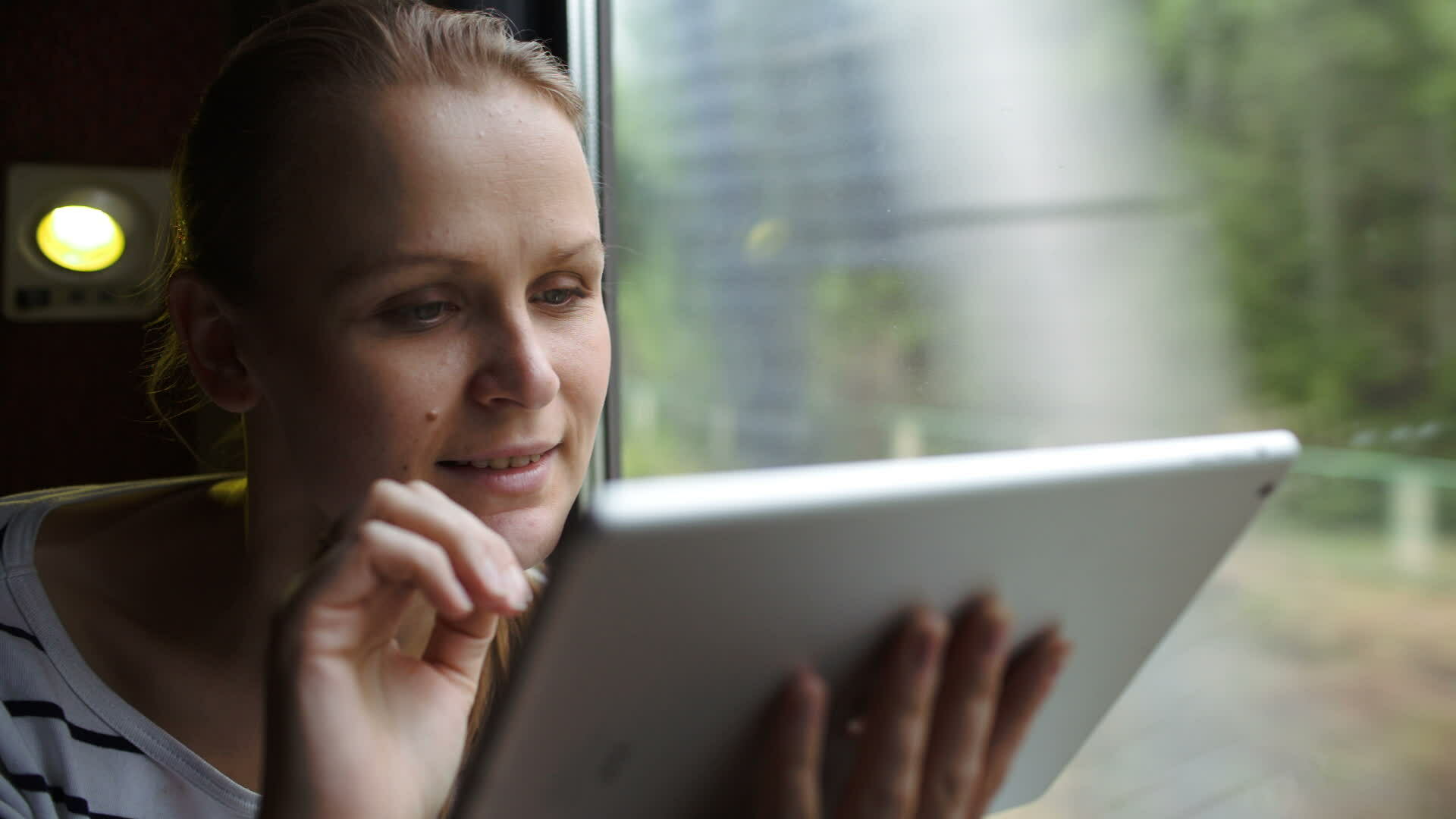 Young woman using touch pad sitting by the window in train 28257882