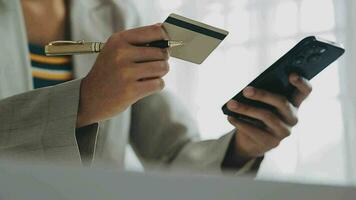 Close up woman hand using credit card and smartphone laptop for buying online shopping video