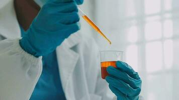 hand of scientist with test tube and flask in medical chemistry lab blue banner background video