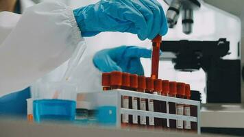 hand of scientist with test tube and flask in medical chemistry lab blue banner background video