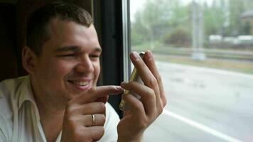 Young man typing sms in moving train video