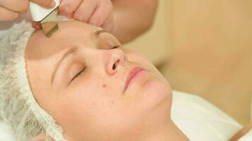 Young woman taking facial treatments of ultrasonic cleaning video