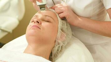 Woman getting ultrasonic face cleaning at beauty spa video