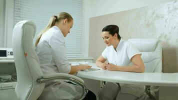 Two cosmeticians talking in the office room video