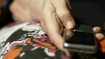 anziano donna composizione un' numero su sua mobile Telefono video