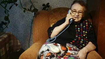 alt Frau Empfang ein Telefon Anruf im das Abend video
