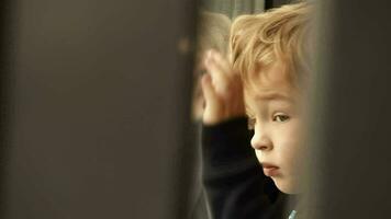 pequeño chico mirando fuera de el ventana video