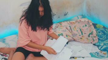een Aziatisch vrouw met een benadrukt gezicht opruimen omhoog de papier verspilling in haar kamer video