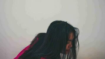 un asiático mujer estaba llorando y triste mientras gateando en su habitación porque ella estaba intimidado video