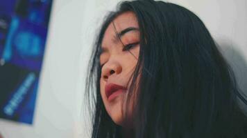 an Asian woman feels anxious and sad when she is bullied by her friends on social media video