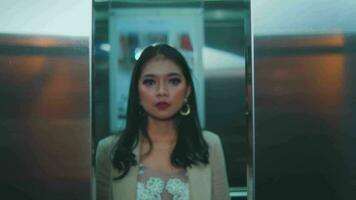 ein asiatisch Frau im ein schön passen und bilden Spaziergänge von ein Aufzug zu Arbeit video