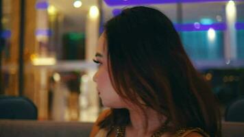un asiatico donna sega un' donna a piedi nel il Hotel atrio con un' cinico e disgustato viso a un' Hotel video