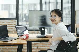 Young programmer working on desktop PC in office of software company. photo