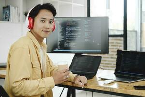 joven programador trabajando en escritorio ordenador personal en oficina de software compañía. foto