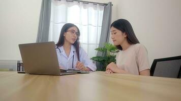 Beautiful asian woman doctor examining young woman in a hospital. photo