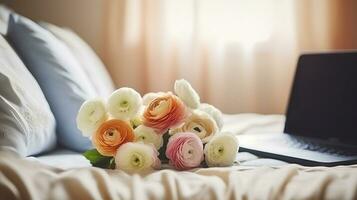 Empty unmade bed with ranunculus flowers. Close up shot of beautiful spring bouquet and laptop with open lid in bedroom interior. Good morning concept. AI Generative photo