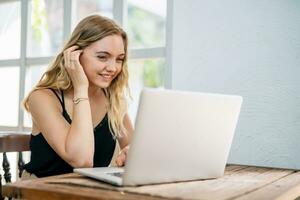 A woman sitting happily shopping online with laptop. Online shopping concept. photo