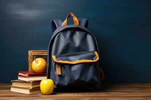 School bag and textbooks in front of a blackboard on a school desk. Back to school concept. photo