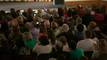 People seated in an audience and applauding video