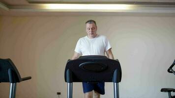 Middle-aged man working out on a treadmill video