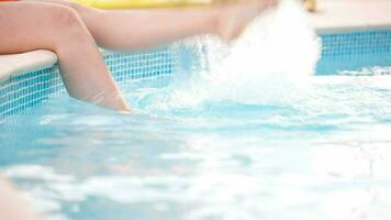 Woman splashing feet in the pool video