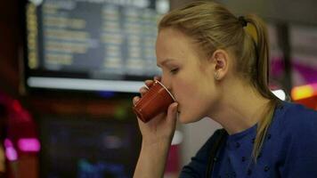 vrouw in wachtkamer met koffie en touchpad video