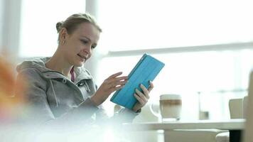 mujer en café utilizando su touchpad video