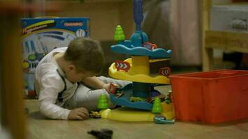 pequeño chico jugando con un el plastico estacionamiento garaje video