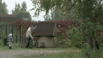 Grandfather and grandson near well video