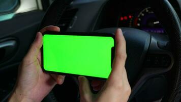 Hand using phone green screen at car, green screen video