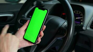 main en utilisant téléphone vert écran à voiture, vert écran video